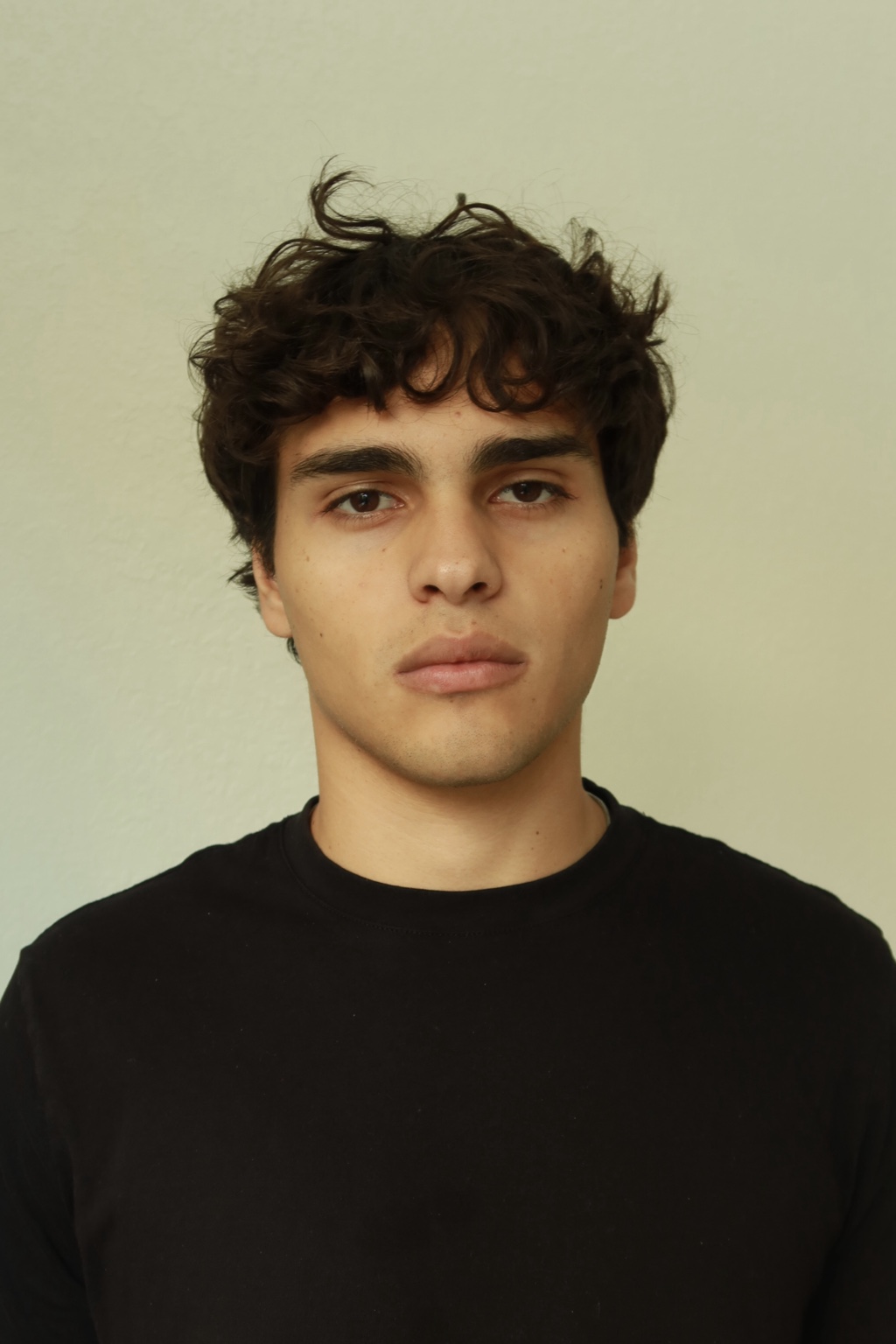 Portrait of a man against a pale green wall